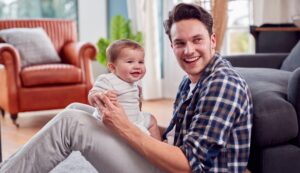 Homem trans com um bebê no colo