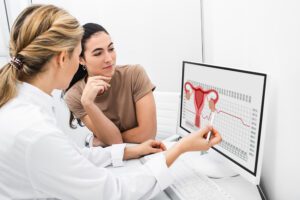 Médica explicando para paciente sobre útero.
